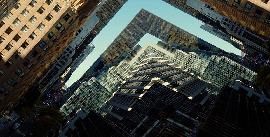 Aerial view of high-rise buildings forming an L-shaped gap and sharp skyline, highlighting urban density and geometry.​