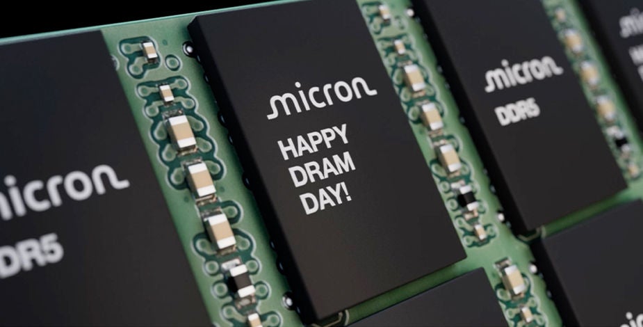 Close-up view of multiple Micron DDR5 memory chips on green circuit board, one reads “Happy DRAM day!”