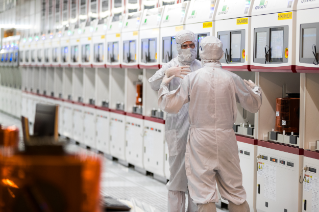Two men wearing lab coat from head to toe and standing the laboratory