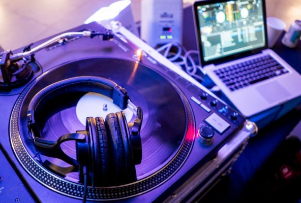 Record player and headset next to laptop.