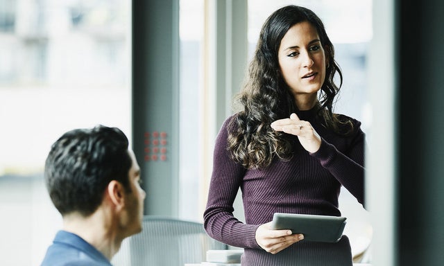 Women speaking to collegues with a tablet in hand