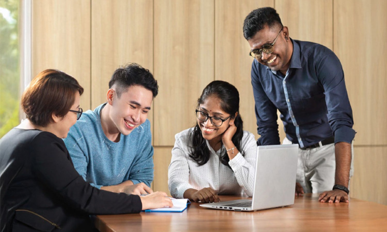 group of people having a discussion with a laptop infront of them