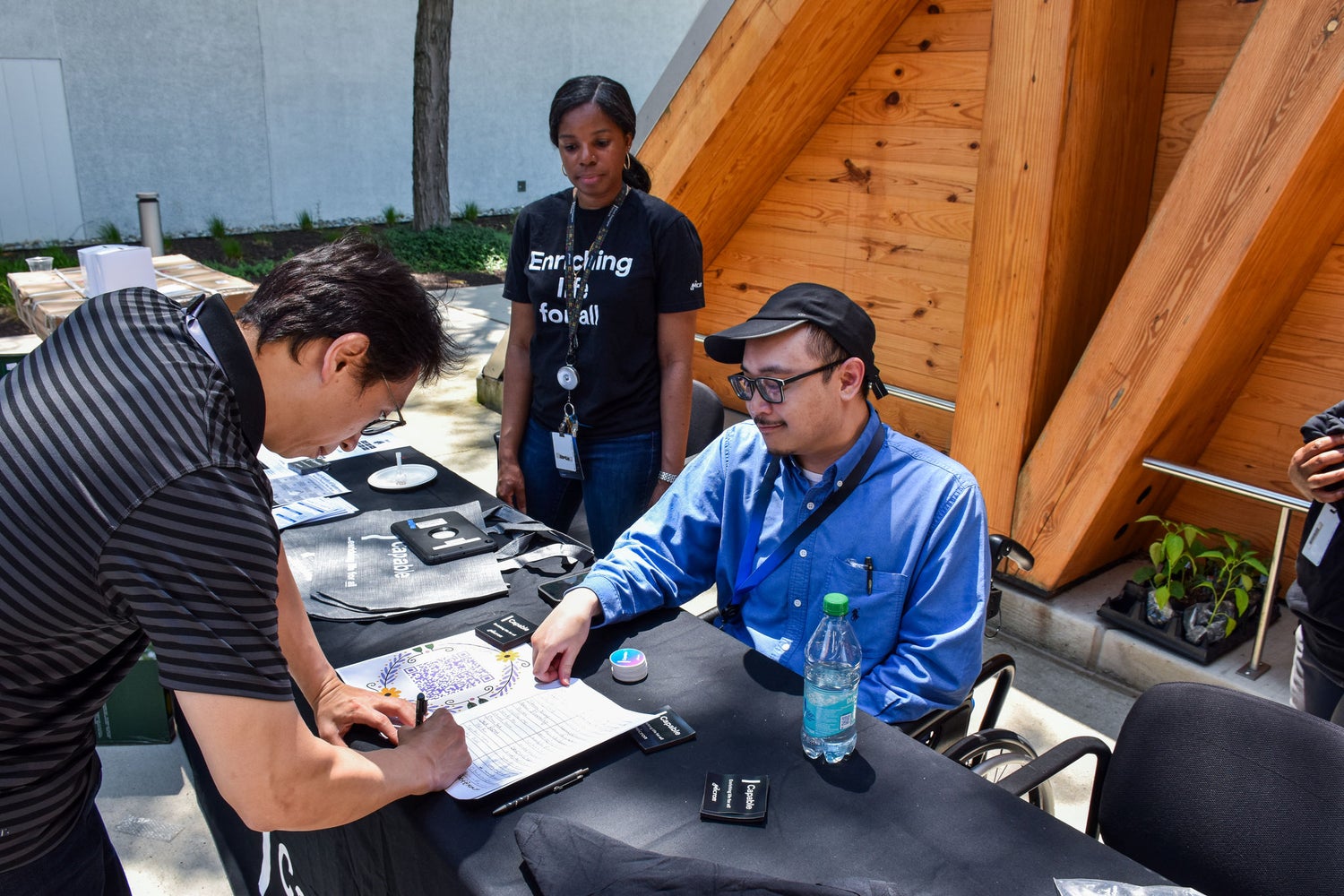 Community members registering and engaging at an outdoor volunteer event.