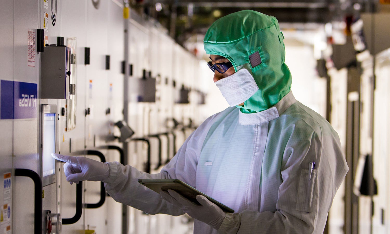 Fabrication plant worker in a clean suit working