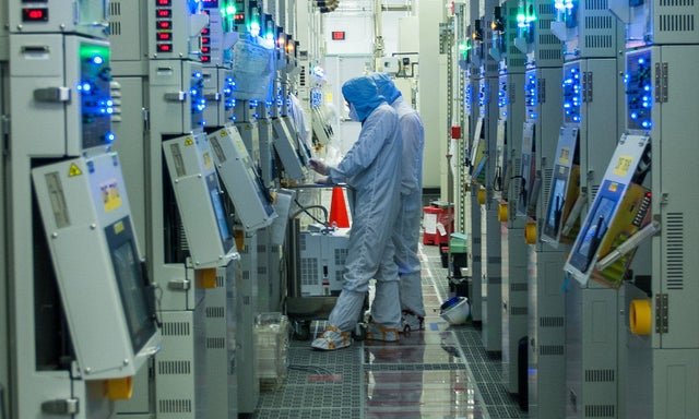 Two fabrication plant workers working at a terminal