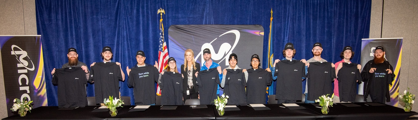 hero_211113-micron-0021-2000x500.jpg: picture of 12 Micron apprentices in front of blue drape