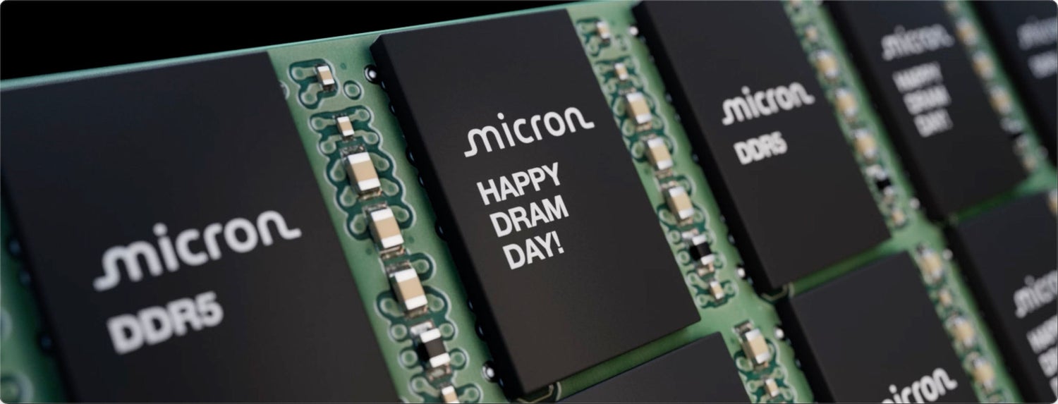 Close-up view of multiple Micron DDR5 memory chips on green circuit board, one reads “Happy DRAM day!”