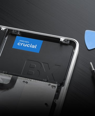 Un SSD Crucial da 2,5 pollici appoggiato a una tastiera.