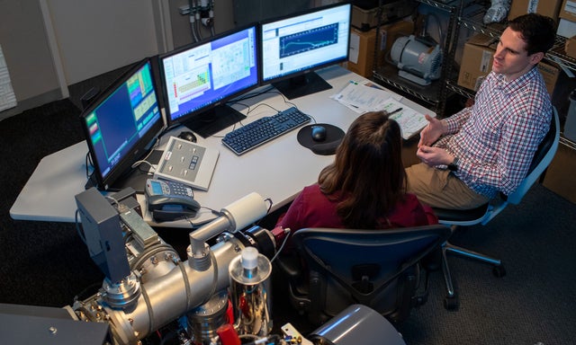 Co-workers collaborating at a computer console in a lab