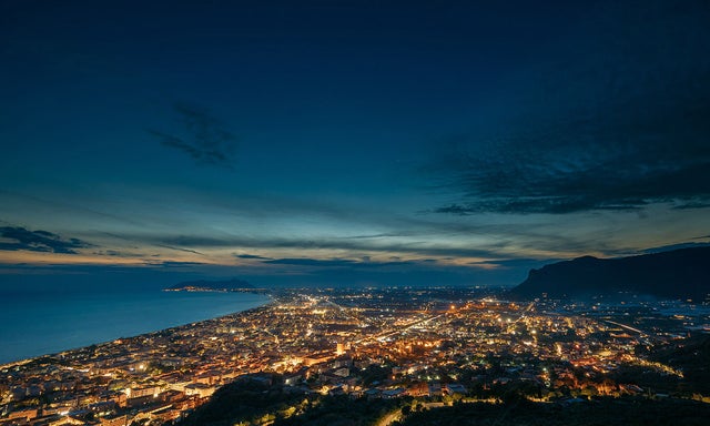 Aerial view of city by the sea at night
