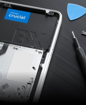 A Crucial 2.5-inch SSD leaning against a keyboard.