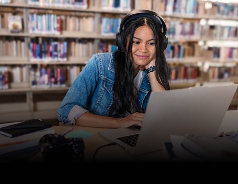 Two girls in a classroom setting working on a robotics assignment on a laptop.