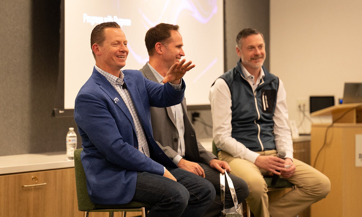 Panel discussion at a Micron community event with speakers seated on stage.