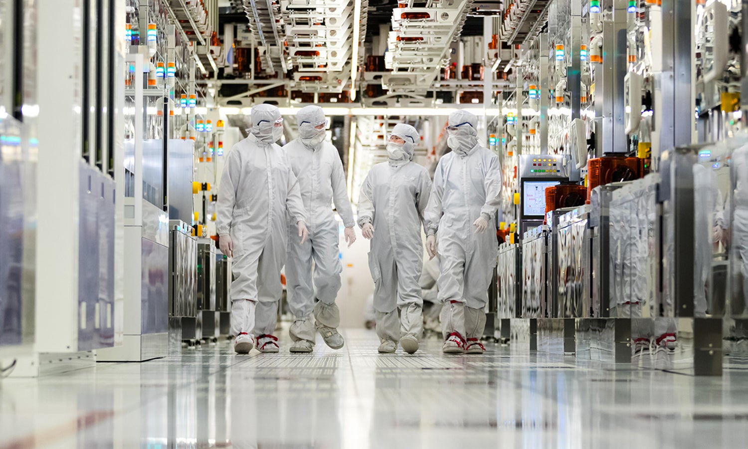 Clearn room employees walking down the hallway of a fabrication plant