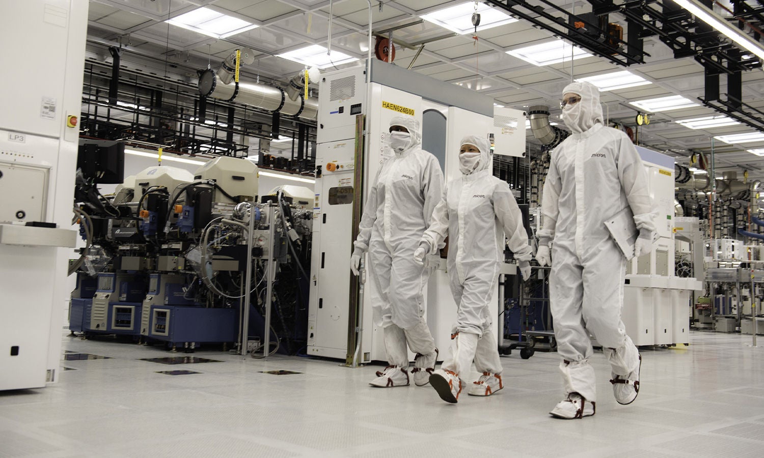 Three fab workers cleanroom suits