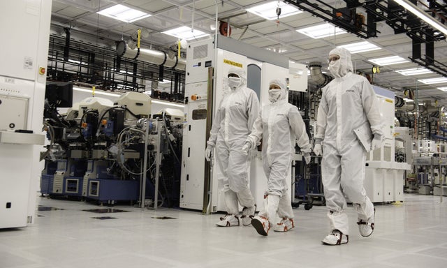 Three fab workers cleanroom suits