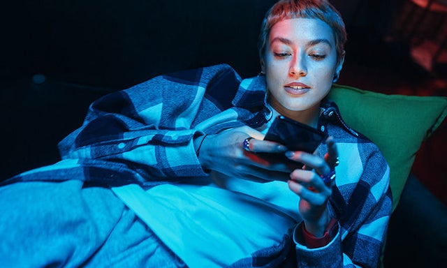 person typing on smart phone at night
