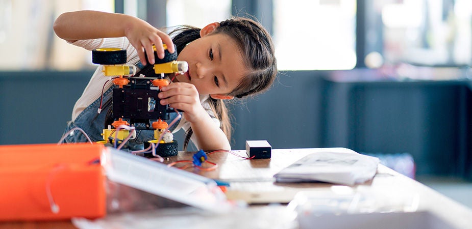 Young girl working on a robot