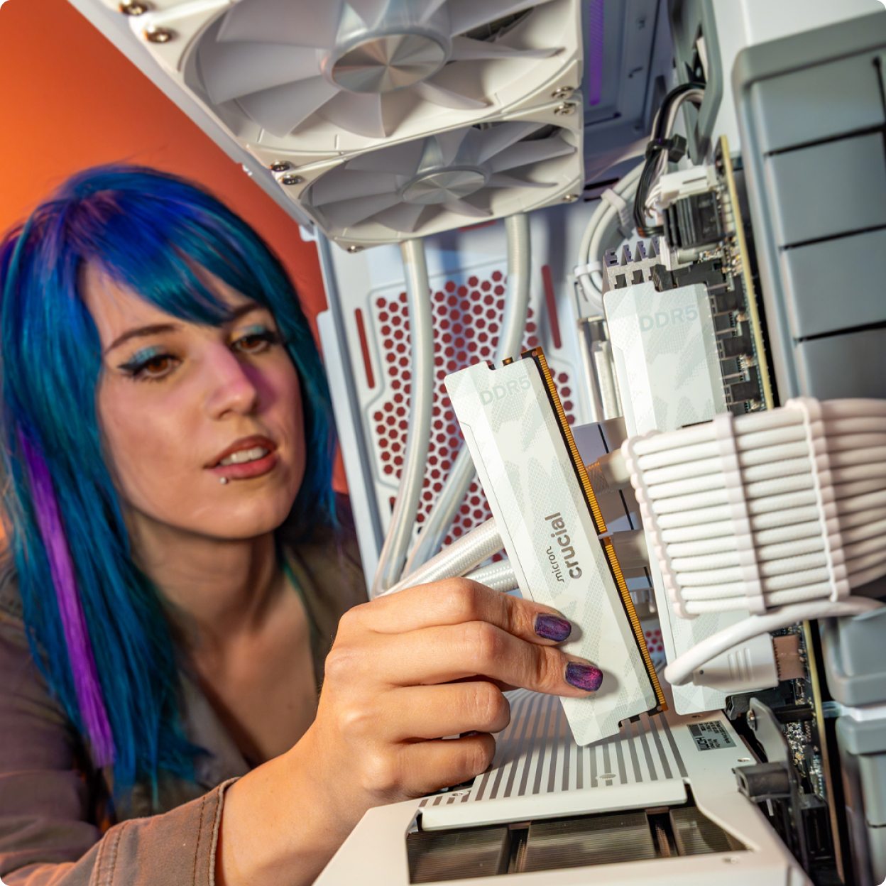 A girl gamer sitting at desk playing video games with pink headphones and pink lights