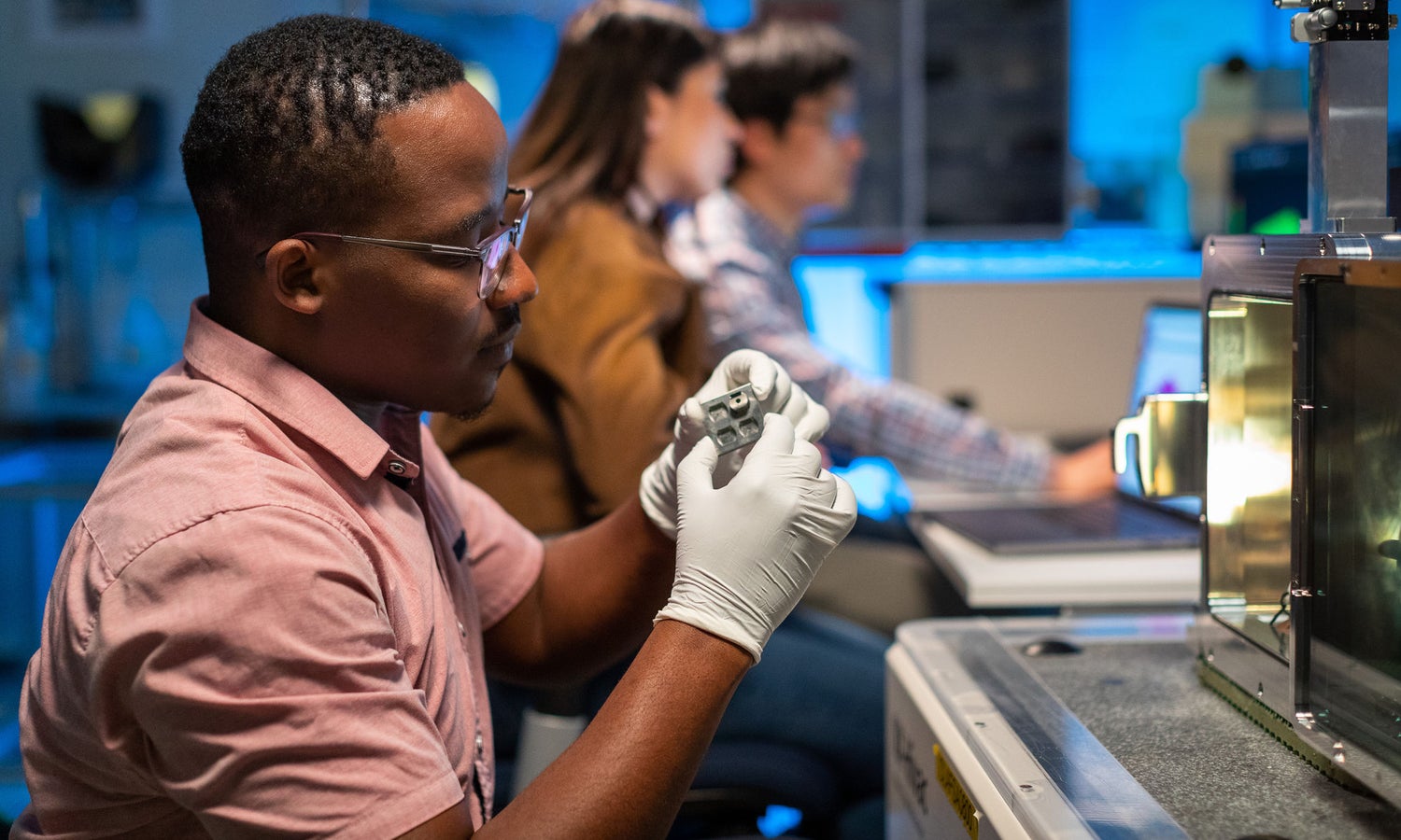 Surface analytics lab worker inspecting a part