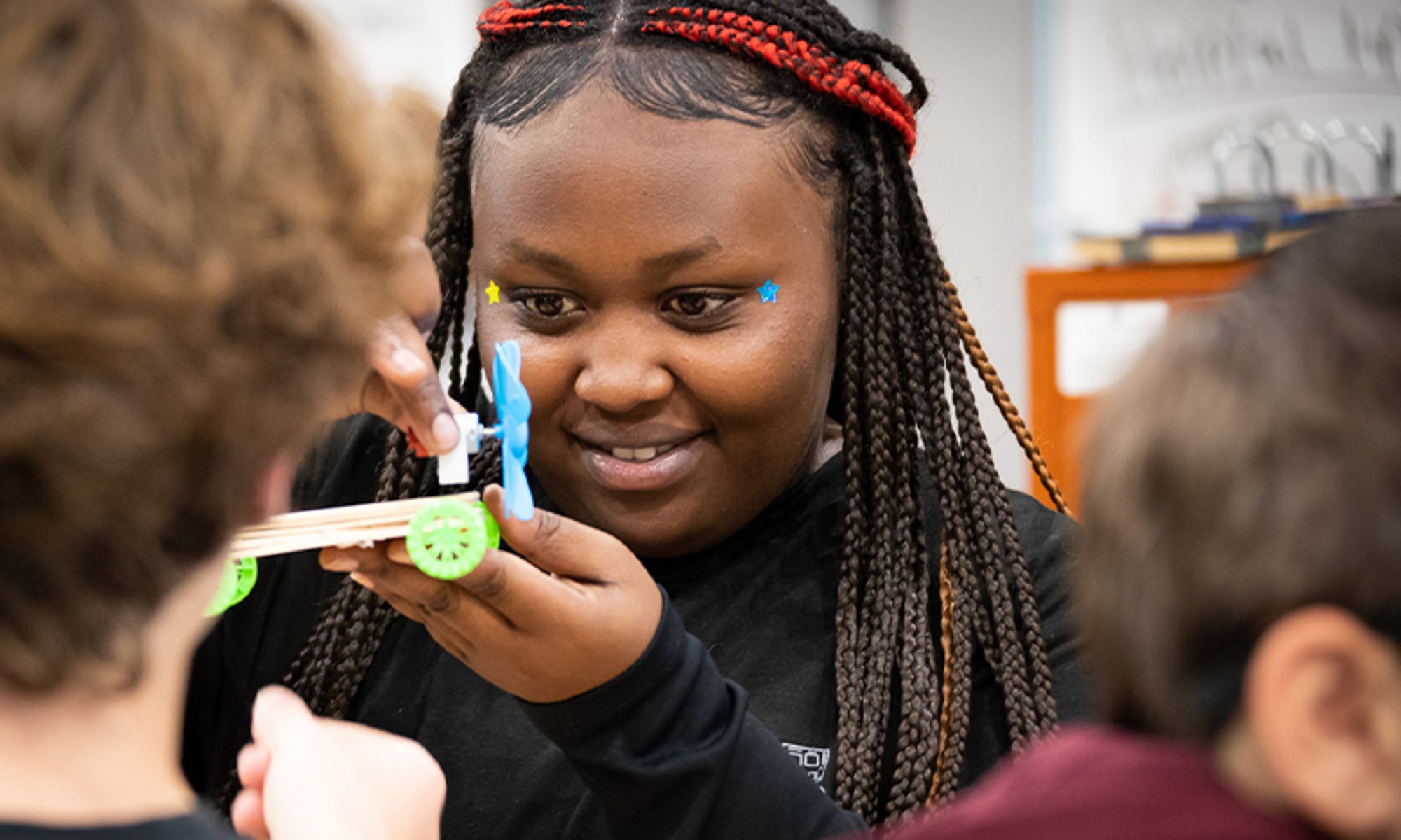 Student building and testing a small engineering project during a STEM learning activity.