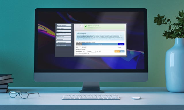 A computer monitor, keyboard, and mouse on a desk in an office.