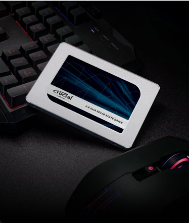 A Crucial 2.5-inch SSD leaning against a keyboard.