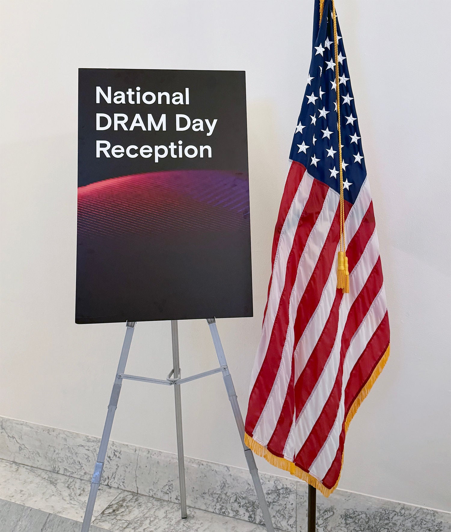 An American flag standing next to a sign reading 'National DRAM Day Reception