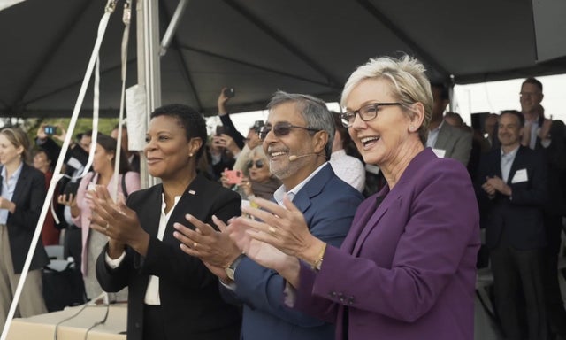 Executives and politicians clapping at ceremony