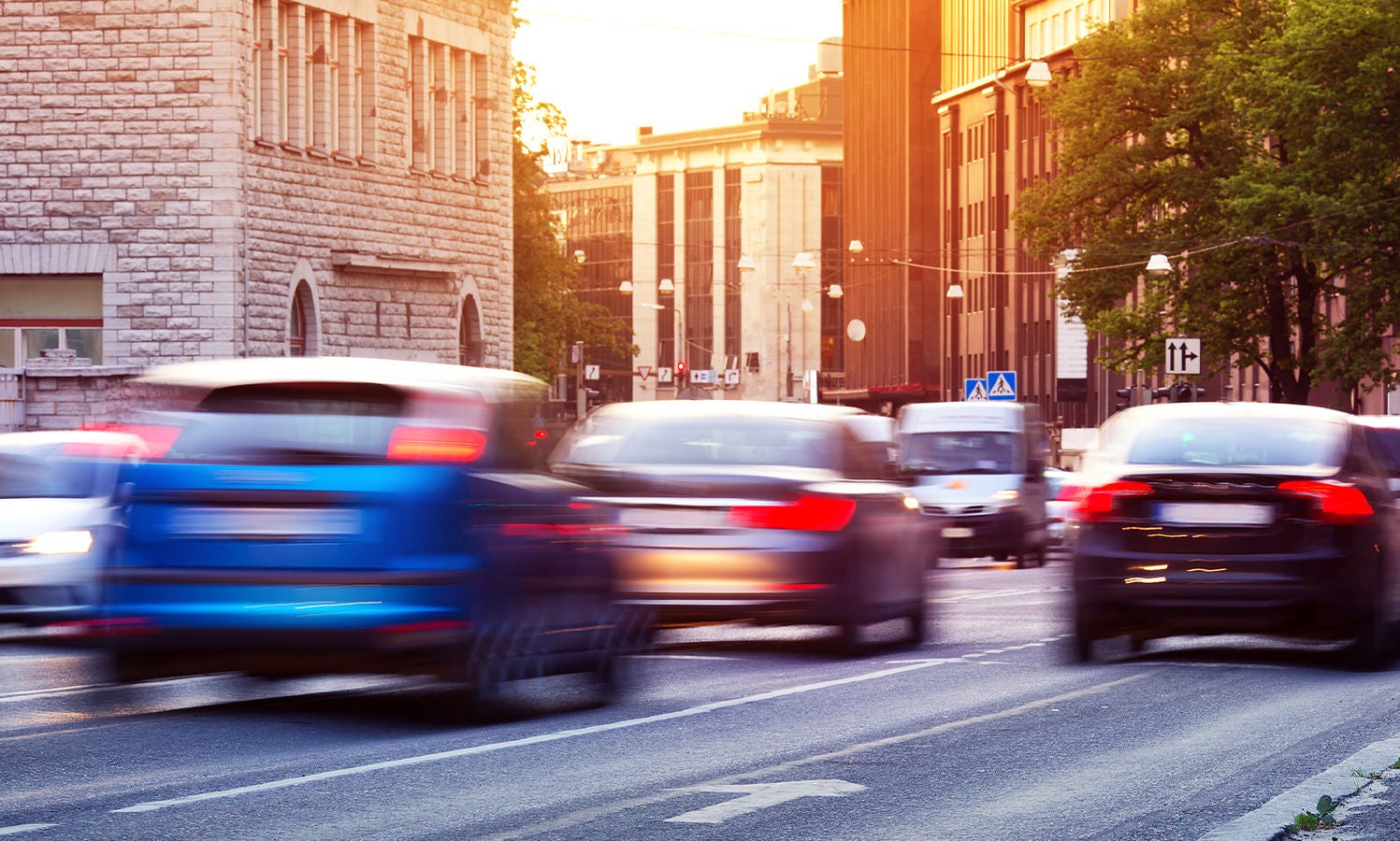 Motion-burred vehicles moving down a town road