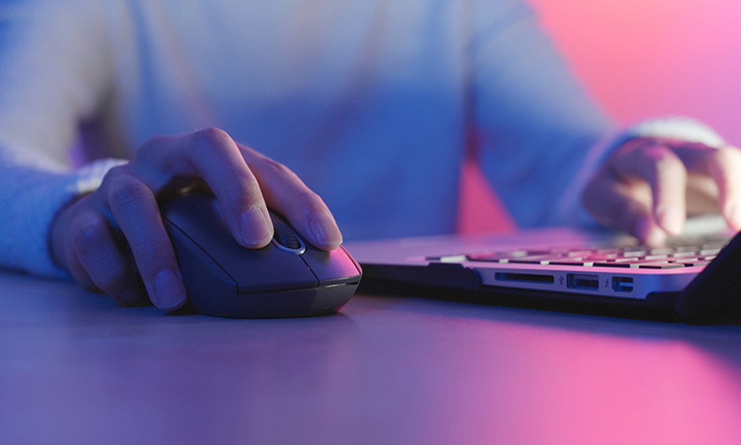 Woman using a mouse at a laptop