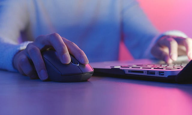Woman using a mouse at a laptop
