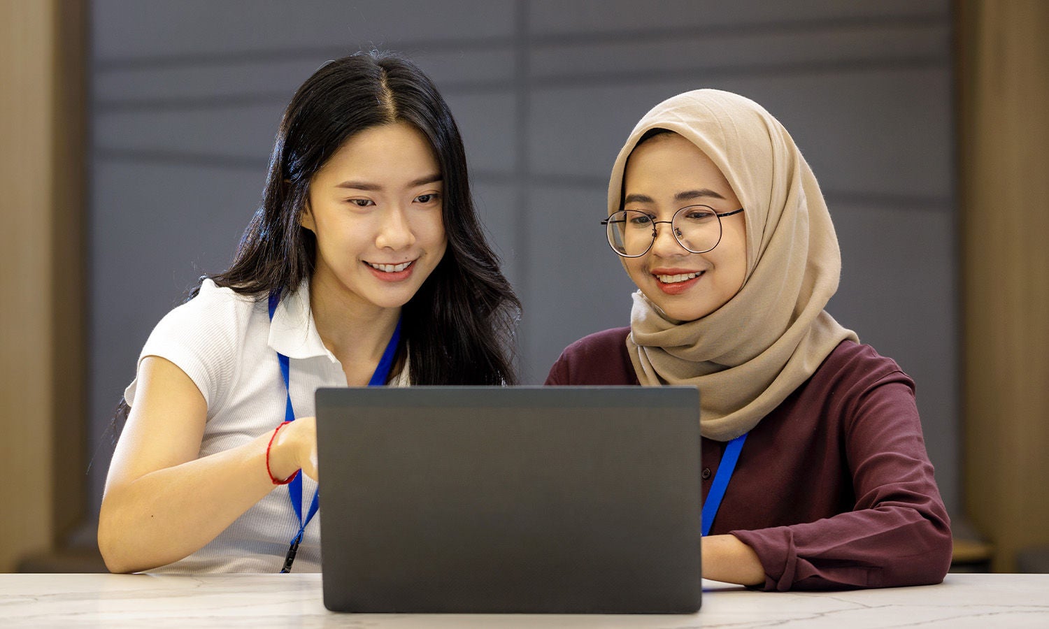 Two co-workers working at a laptop