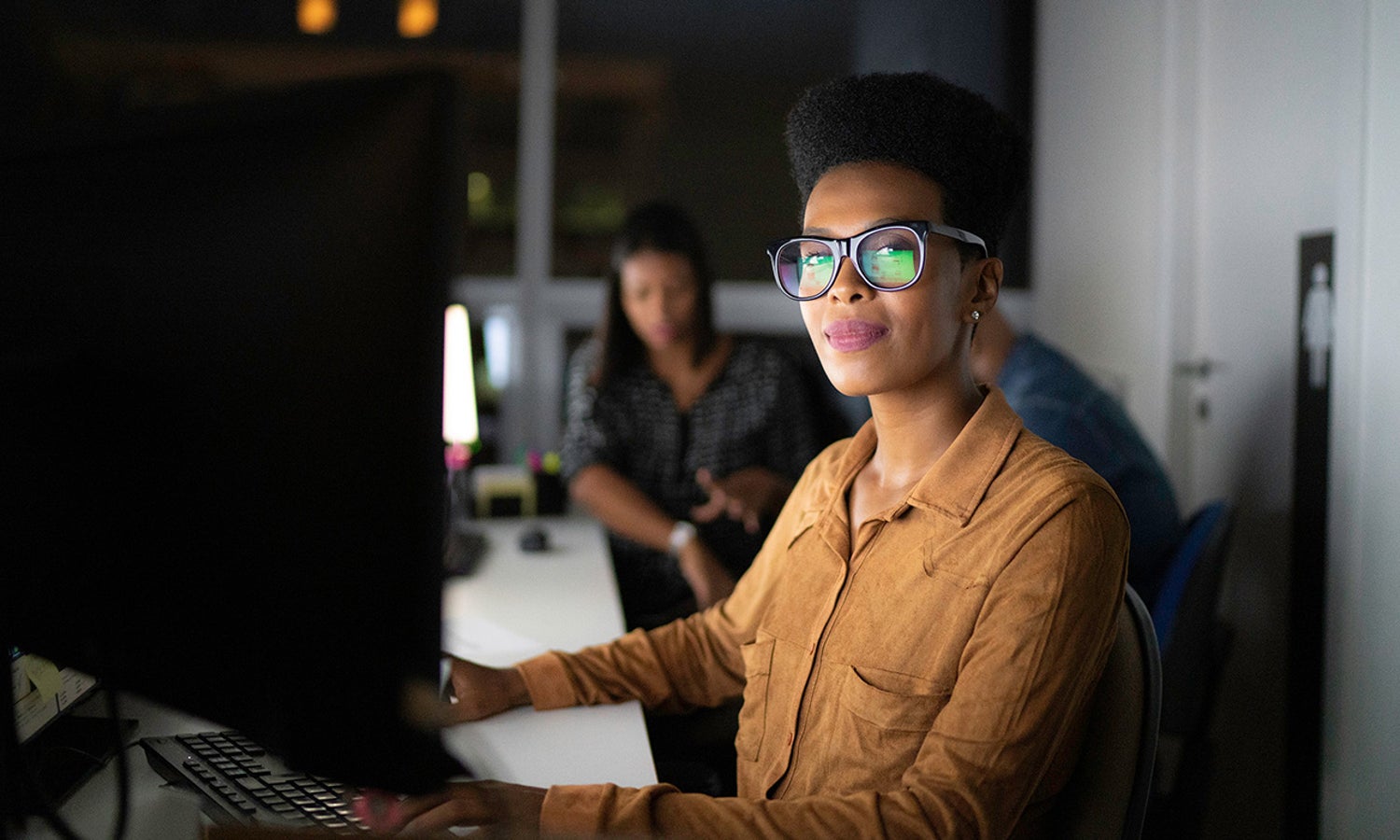 Woman in a dark office working at her computer