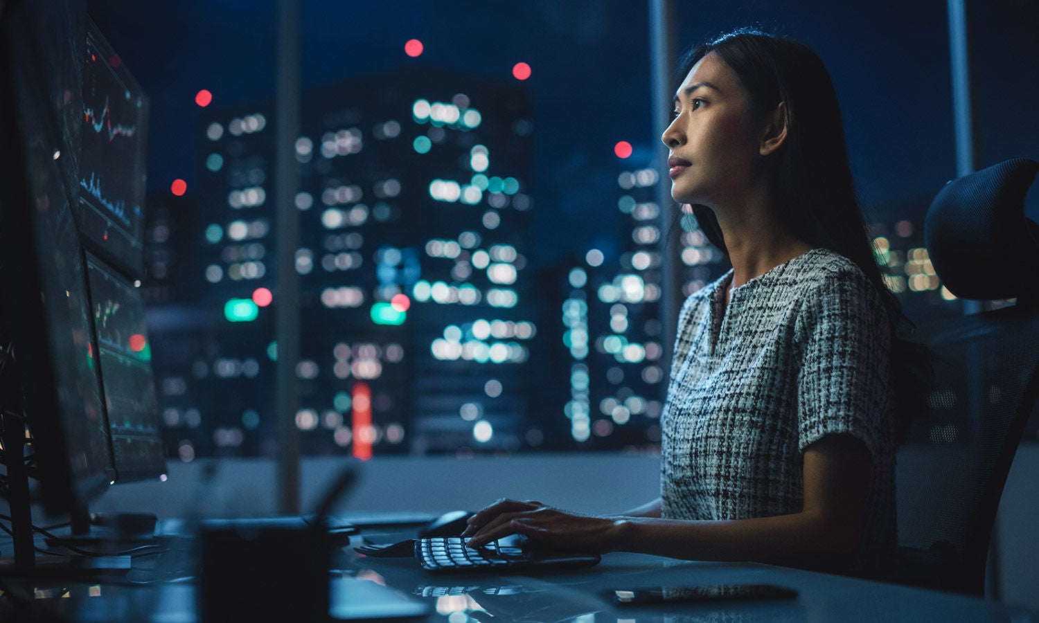 Woman working on financial monitoring in front of 6 monitors​