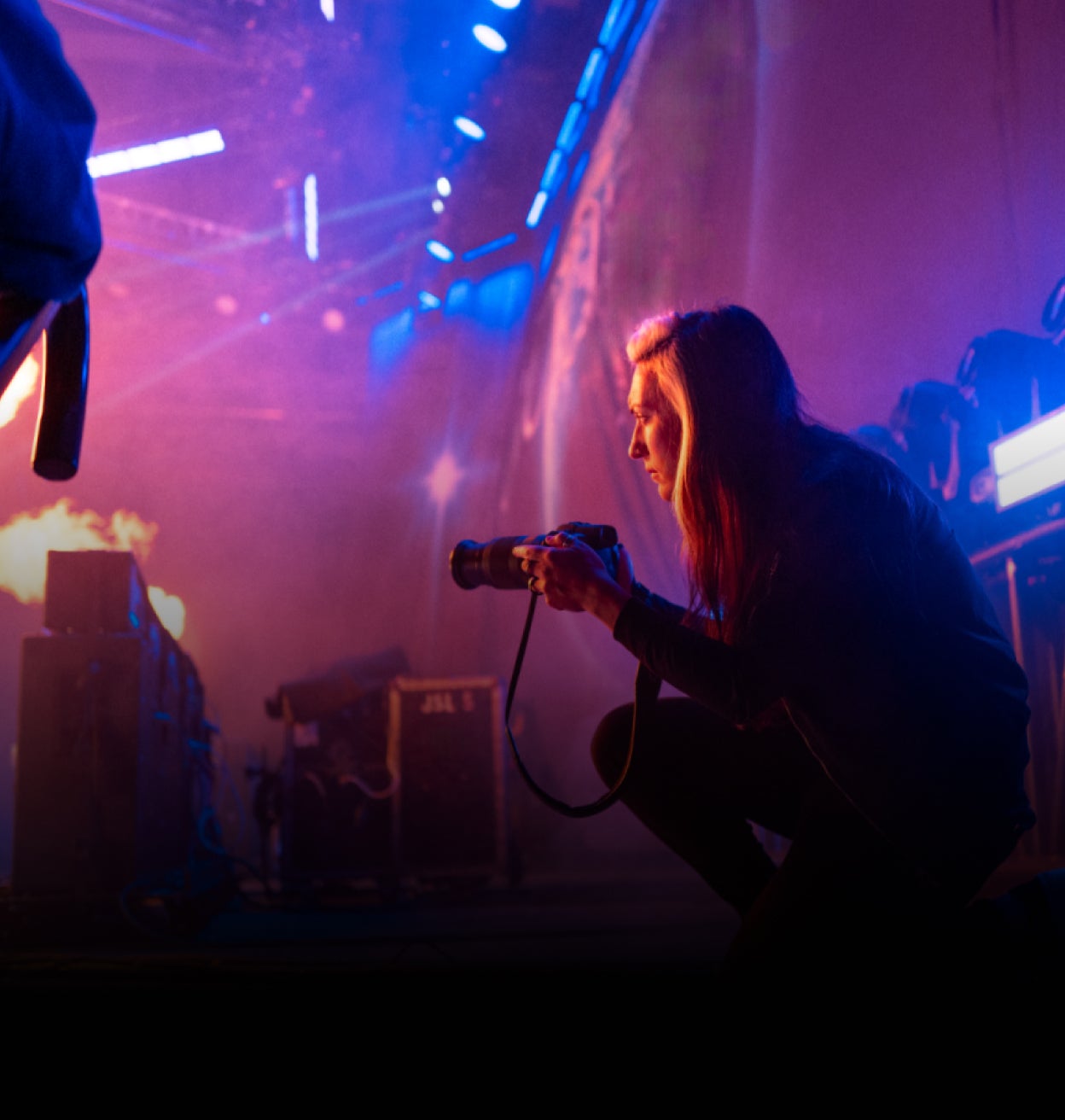  Una mujer sentada en un balcón con vistas a un bosque y trabajando en un ordenador portátil.