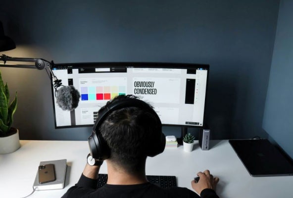 Back of person's head as he looks at screen.