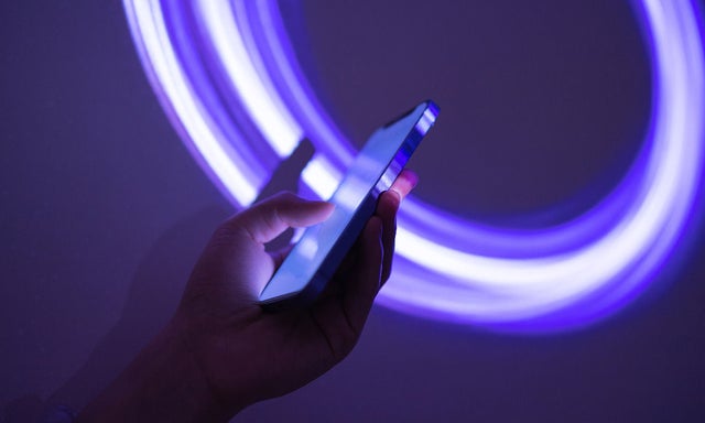 Hands working on a phone in the dark
