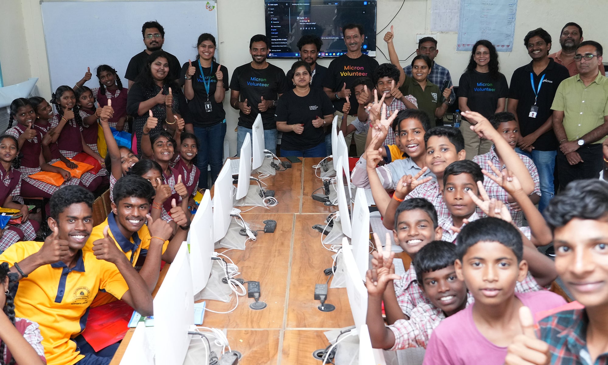 Micron volunteers and students gathered in a computer lab during a STEM learning and mentorship event.