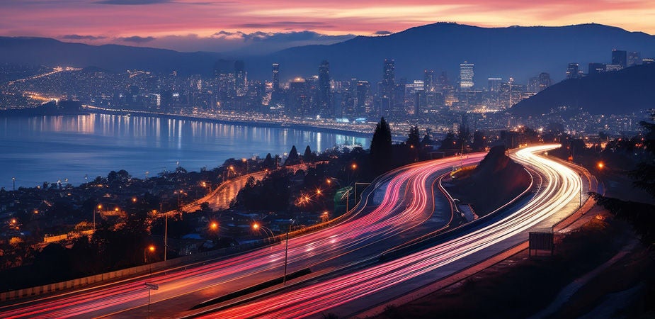 bridge of light streams over city bay at night