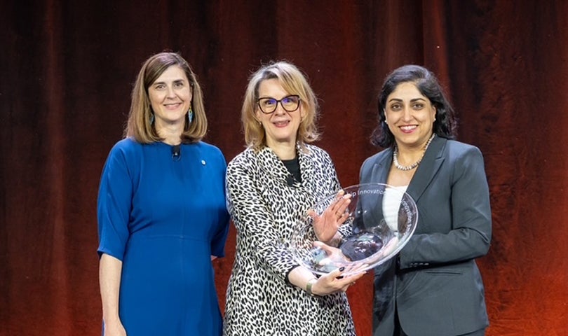 Individuals receiving an award on stage during a ceremony.