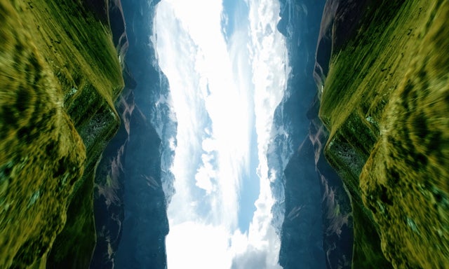 Mirrored mountain landscape with bright sky, creating a surreal vertical symmetry.