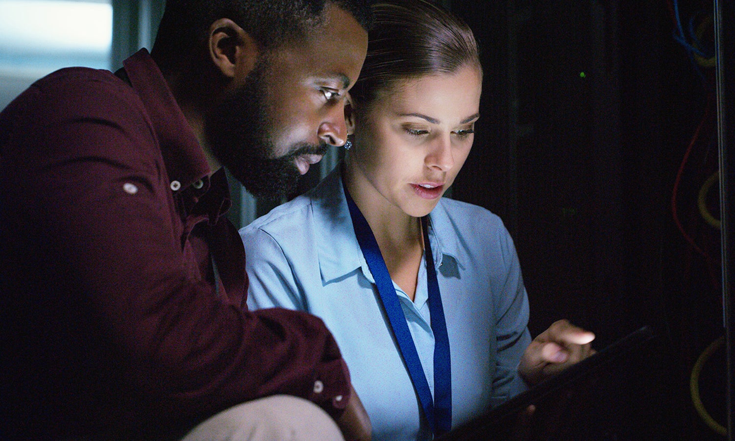 Two co-workings looking over a screen, working together.