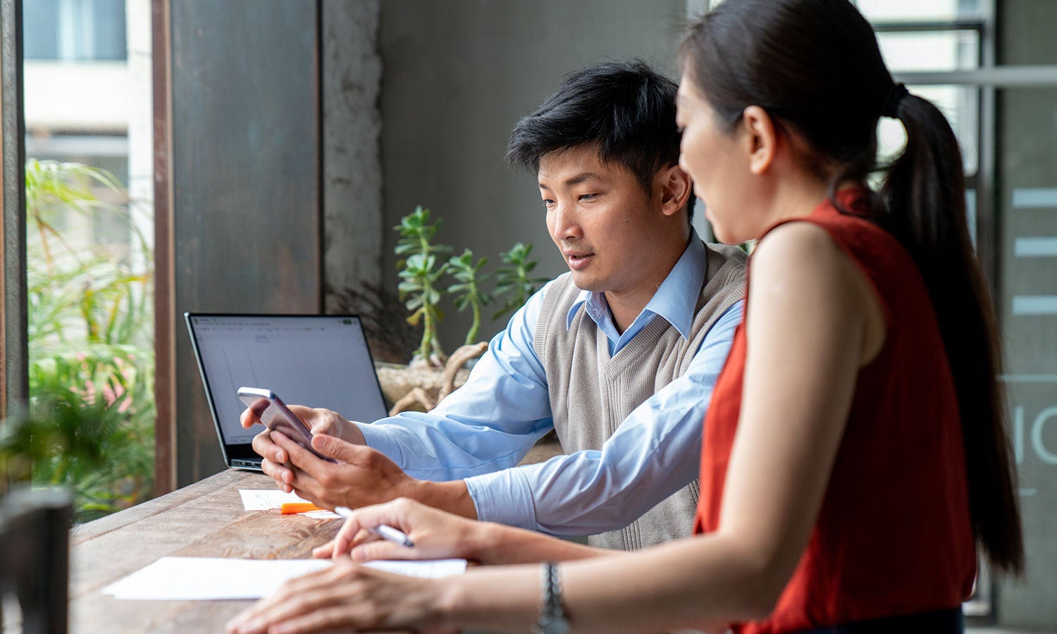 1181338559-coworkers-at-desk-with-computer-and-mobile